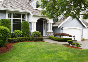 Newly painted exterior of a North American home during summertime with green grass and flower beds